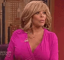 a woman in a pink dress is standing in front of a door .