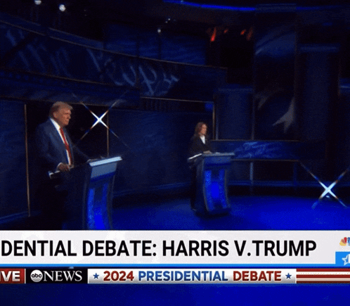 a man stands at a podium with the words denial debate harris v. trump behind him