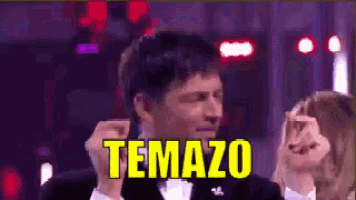 a man in a tuxedo is making a funny face with the word temazo above him