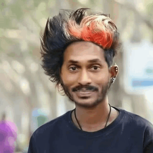a man with a mustache and red and black hair is wearing a black t-shirt .
