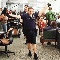 a man in a police uniform is standing in a crowded room with his arms outstretched