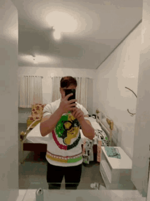 a man taking a picture of himself in a mirror in a bedroom