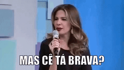 a woman is holding a microphone and saying mas ce ta brava .