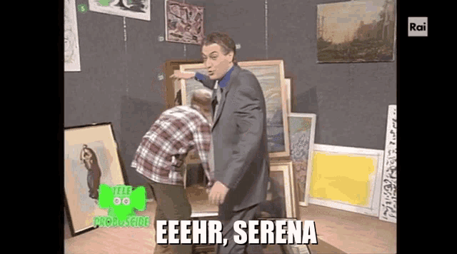 a man in a suit stands next to a man in a plaid shirt and says eeehr serena on the screen