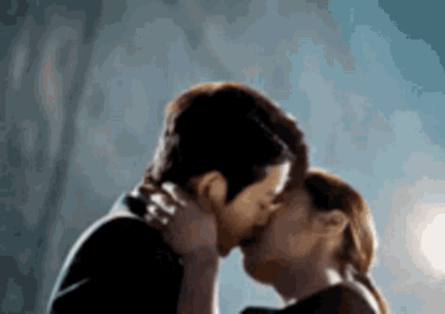 a man and a woman are kissing each other in a dark room .
