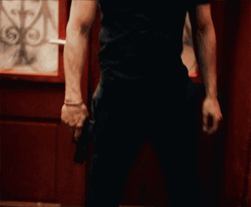 a man in a black shirt is holding a gun
