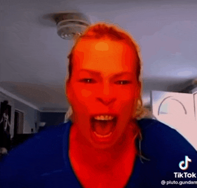a woman is making a funny face with her mouth open and her face is red .