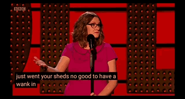 a woman stands in front of a microphone and says just went your sheds no good to have a wank