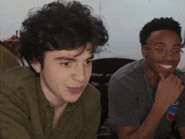 two young men are sitting next to each other and one of them has a t-shirt that says iced tea on it