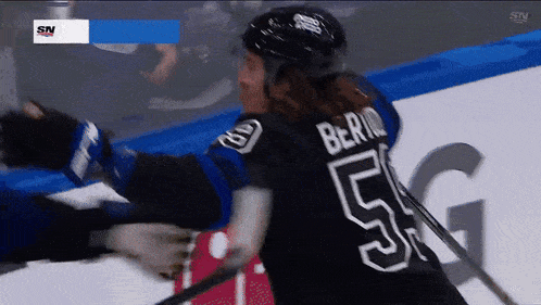 a hockey player wearing a black jersey with the number 5 on it