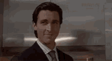 a man in a suit and tie is standing in front of a sign that says maybe i don 't know