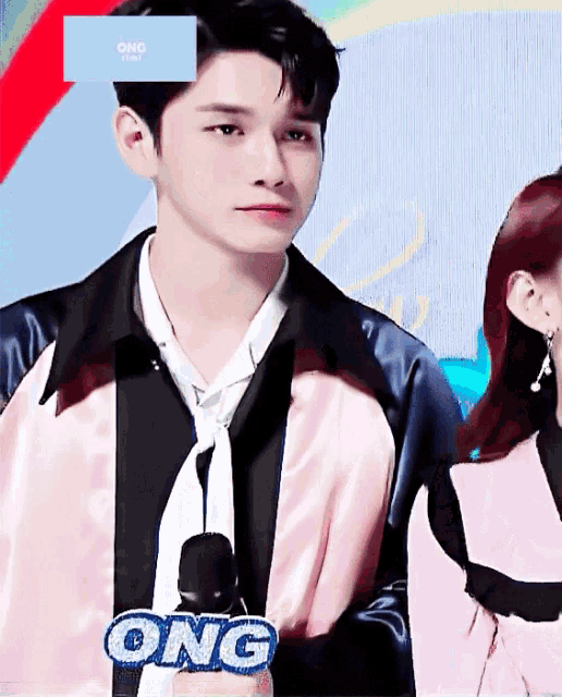 a man in a jacket and tie is holding a microphone that says ong on it