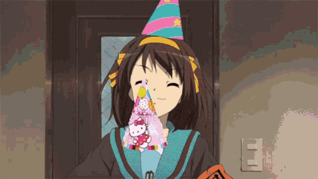 a girl wearing a party hat with a hello kitty cake on her face