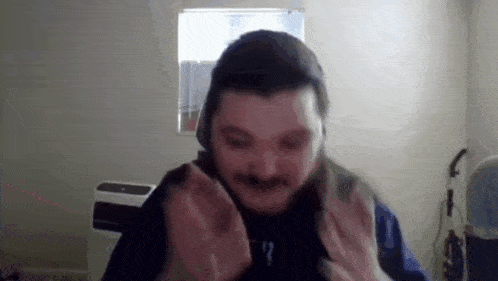 a man with a beard and mustache is making a funny face while wearing headphones .