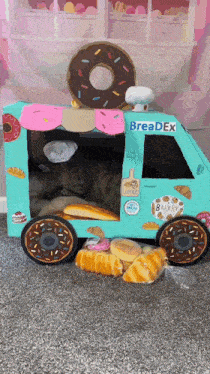 a cat is sleeping in a cardboard breadex truck