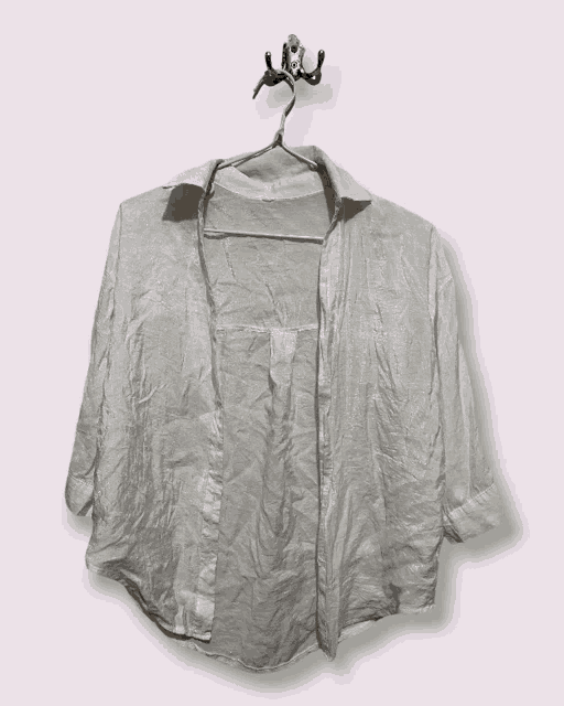 a white shirt is hanging on a hanger with the front open