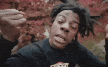 a man with dreadlocks is wearing a black shirt that says fuego on it .