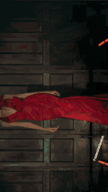 a woman in a red dress is laying down with a bracelet on her wrist