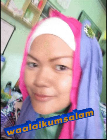 a woman wearing a pink head scarf and a blue sign that says waalaikumsalam