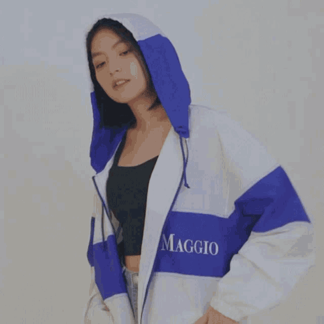 a woman wearing a blue and white jacket that says maggio on it