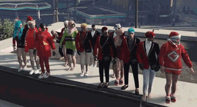 a group of people are walking down a sidewalk and one of them is wearing a santa hat