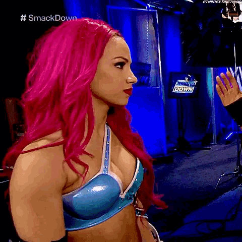 a woman with pink hair is standing in front of a smack down sign