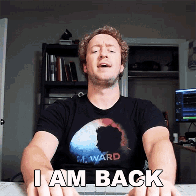 a man wearing a m. ward t-shirt says " i am back "