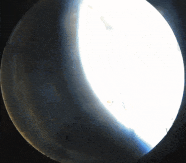 a white light is shining through a dark hole in a dark room
