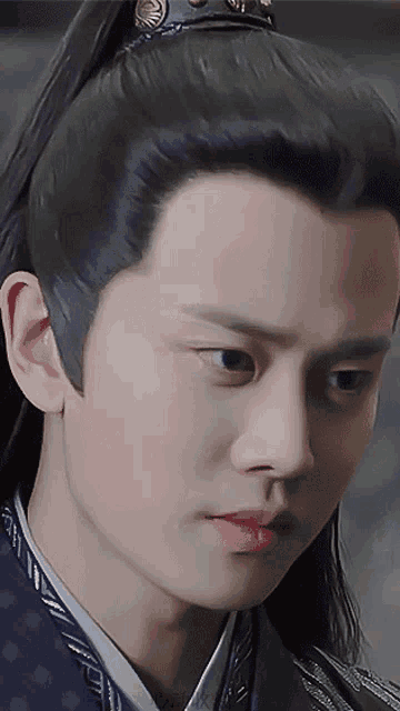 a close up of a man 's face with long hair