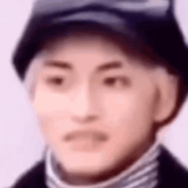 a blurry picture of a man wearing a hat and a striped sweater .