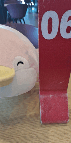 a stuffed animal is sitting next to a red sign that says 00