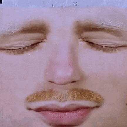 a close up of a man 's face with blue eyes and a mustache .