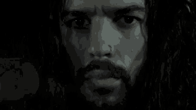 a close up of a man with a beard and a nose ring .