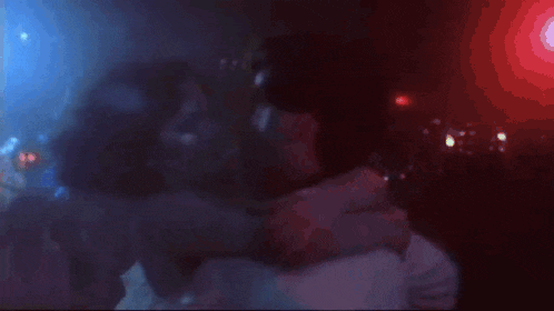 a blurry picture of two people hugging in a club