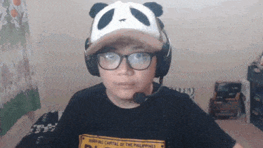 a person wearing a panda hat and a shirt that says ' surfing capital of the philippines ' on it