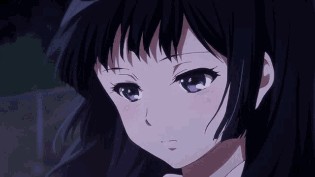a girl with black hair and blue eyes looks sad