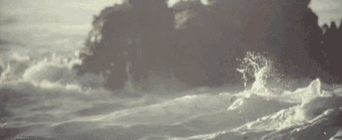 a close up of waves crashing against a rocky shore .