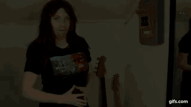 a woman with long hair and a beard is wearing a black shirt that says metal is my music .
