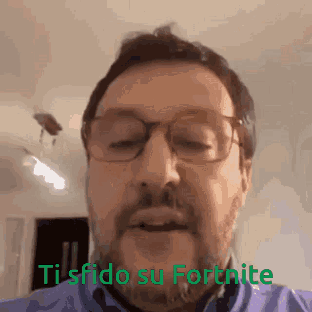 a man with glasses and a beard says " ti sfida su fortnite "