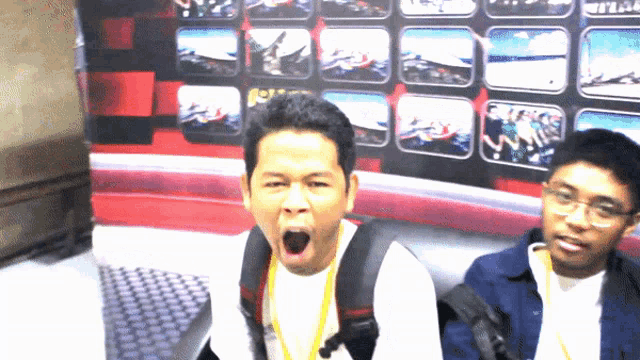 a man making a funny face in front of a wall of pictures