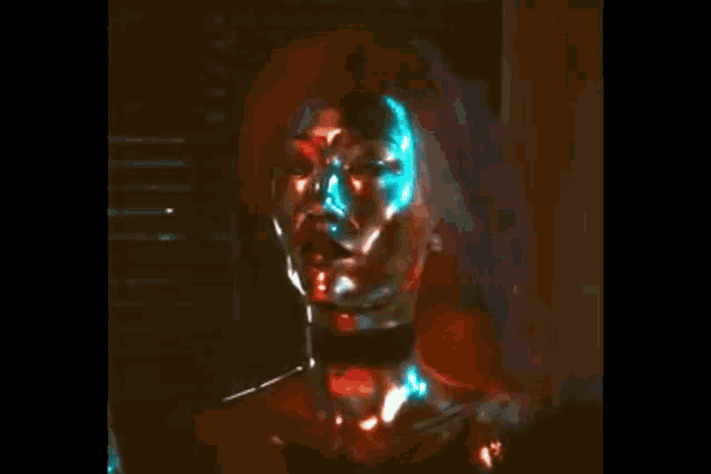 a close up of a woman 's face with a choker around her neck and red hair in a dark room .