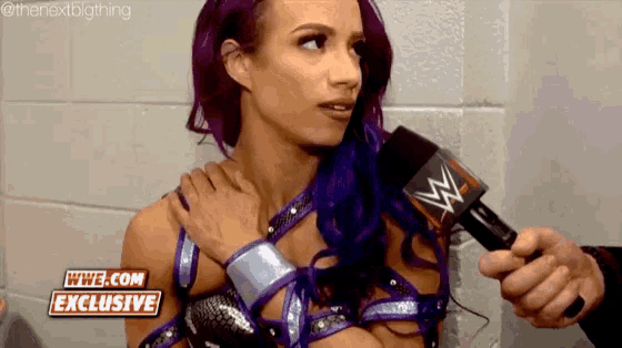 a woman with purple hair is being interviewed by a man with a microphone