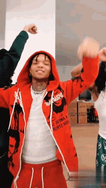 a man wearing a red hoodie that says " high voltage " is dancing