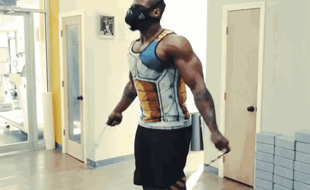 a man wearing a mask and a tank top is jumping a jump rope