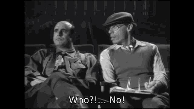 two men are sitting in a theater and one of them is saying " who no "