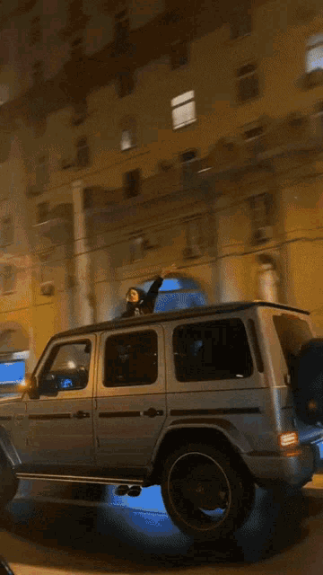 a car with a bird on the roof is parked in front of a building