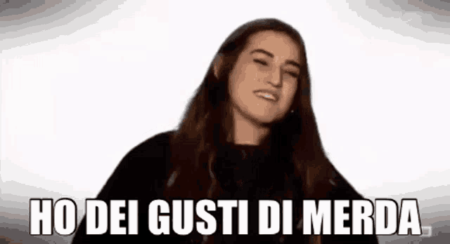 a woman with long hair is making a funny face and saying ho dei gusti di merda .