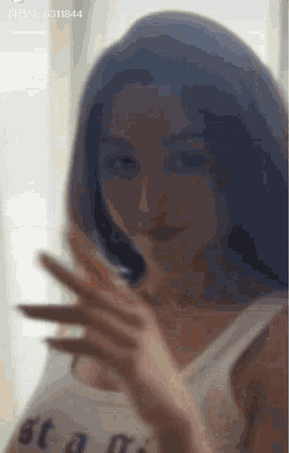 a blurry photo of a woman with the number 6311844 on the bottom right