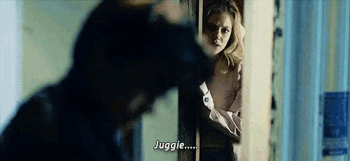 a man and a woman are standing in a room and the woman is talking to the man .