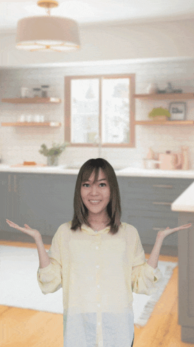 a woman in a yellow shirt is standing in front of a kitchen